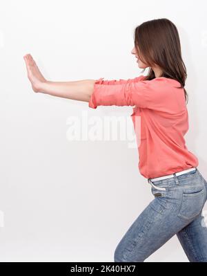 Woman pushing something imaginary - isolated over a white background stock photo Stock Photo