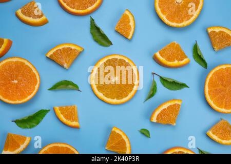 background with slides of orange and leaves on a blue background, trendy summer, fruity background. Stock Photo