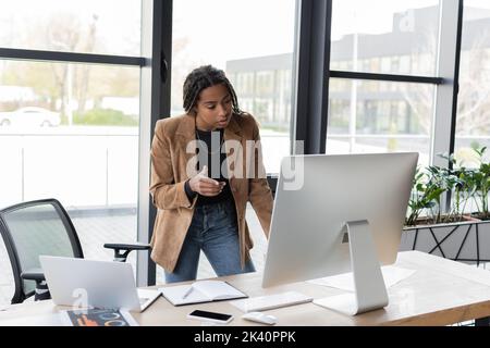 African american businesswoman pointing with finger during video call on computer on office,stock image Stock Photo