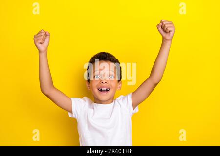 Photo of satisfied boy football fan celebrate rejoice scream yes support favorite team hand arm raise isolated on yellow color background Stock Photo