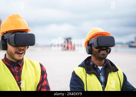 Multiracial workers using virtual reality headsets at Freight Terminal Port - Focus on indian man goggles Stock Photo