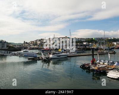 View from King's Quay across Brixham Marina and harbour towards pastel coloured sea front properties Devon England UK Stock Photo