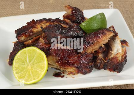 delicious sticky glazed pork ribs with lime on a white plate Stock Photo