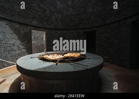 Tasty meat barbecued on volcanic heat, Timanfaya National Park, Canary Islands, Spain Stock Photo