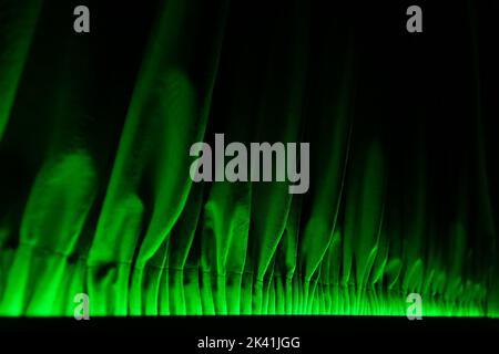 The lower part of the drapery is made of dense fabric, illuminated from below by green LED lighting. Stock Photo