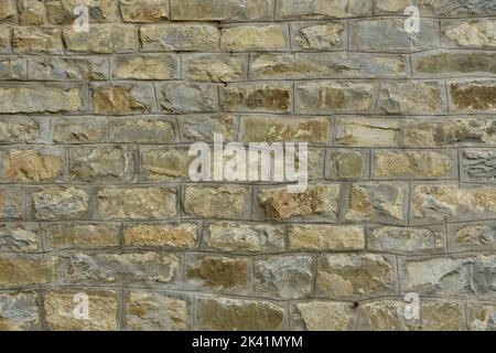 Old big stone wall textured background with green and yellow mold Stock Photo