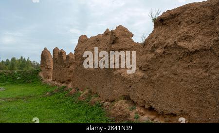 Close-up background of the wall of an old house made of clay mixed with straw. Old type of construction. Clay wall of straw and mud. Stock Photo