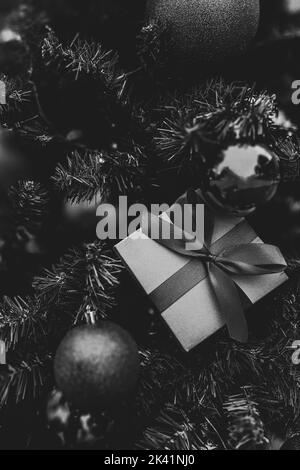 Christmas minimalistic composition in monochrome. Christmas tree gifts, decorations on black background. Stock Photo