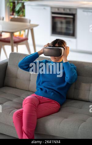 Young woman plays a game in virtual reality in 3D cyberspace simulation headset, futuristic gaming Stock Photo