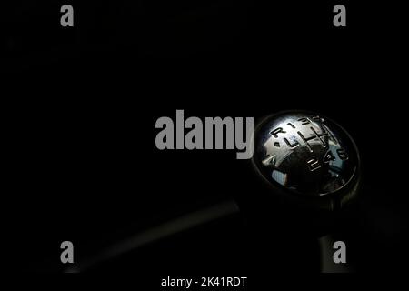 Gear shift lever of the car in the dark background. Image with copy space. Close up of top of gear stick in car interior Stock Photo