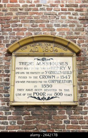 Plaque on the old walls of the historic Almshouses in Poole. Built in the 15th century they have been devoted to the welfare of the poor since 1586 UK. Stock Photo