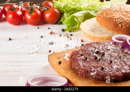 The raw ingredients for the homemade burger on white wooden table. Stock Photo