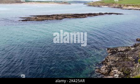 Blue sea water and a rocky shore on a sunny day. Aerial photo. Stock Photo