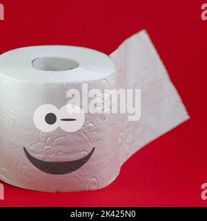 Toilet paper with a funny face against a red background Stock Photo