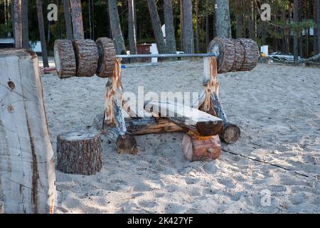 Wooden bench press equipment in a park made of heavy logs. Stock Photo