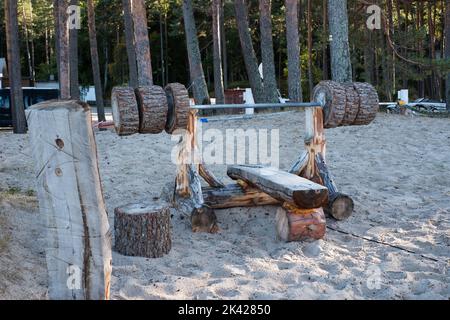 Wooden bench press equipment in a park made of heavy logs. Stock Photo