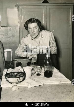Italian singer Carla Boni at home cooking lunch, Italy 1950s Stock Photo