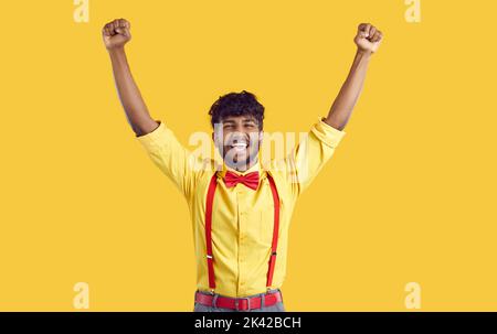 Triumphant happy and satisfied stylish arab guy sincerely rejoices on orange background. Stock Photo