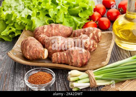 topinambur on a plate on wood background Stock Photo