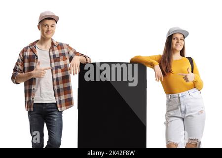 Male and female teens with a big smartphone pointing at the screen isolated on white background Stock Photo