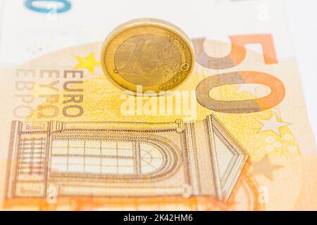One Euro coin on the 50 Euro note banknote Stock Photo