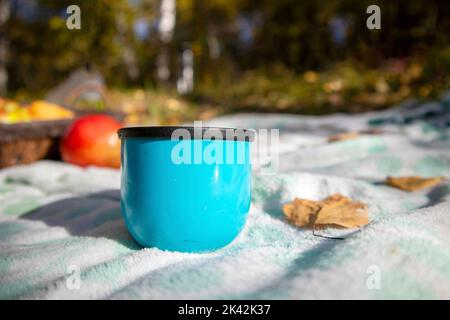 a blue cup from a thermos at an autumn picnic Stock Photo