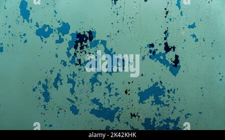 Closeup of painted metal with worn peeling green, blue and black paint. Stock Photo