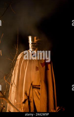 Templar Knight by fire, burning perhaps of fallen brothers in arms. Stock Photo