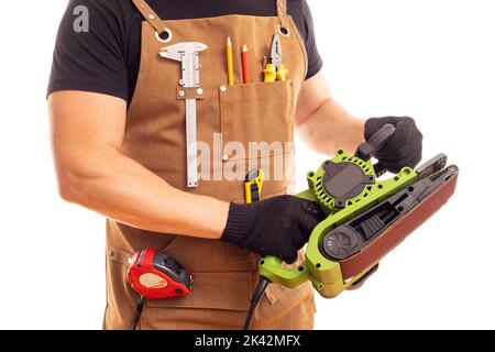 Carpenter in workers apron holding belt electric sander on white background Stock Photo