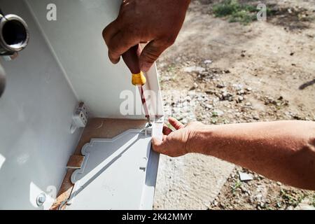Man hands using a screwdriver tool Stock Photo