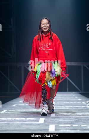 SHANGHAI, CHINA - SEPTEMBER 29, 2022 - Niu Yu, a Wenchuan earthquake survivor, walks with a mechanical leg as she completes the Pony brand runway show Stock Photo