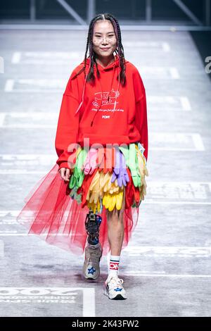 SHANGHAI, CHINA - SEPTEMBER 29, 2022 - Niu Yu, a Wenchuan earthquake survivor, walks with a mechanical leg as she completes the Pony brand runway show Stock Photo