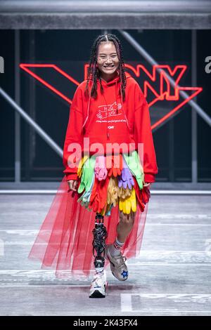 SHANGHAI, CHINA - SEPTEMBER 29, 2022 - Niu Yu, a Wenchuan earthquake survivor, walks with a mechanical leg as she completes the Pony brand runway show Stock Photo