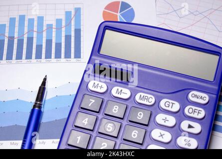 blue image with calculator and metal pen. Stock Photo
