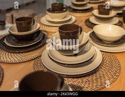 Empty plates and cups on wooden table. Ceramic tableware. Nobody, blurred, selective focus. Stock Photo