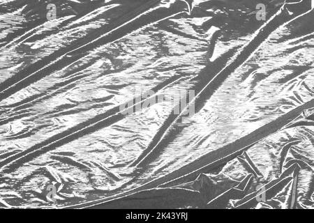 Reflecting light and shadow on creases and folds in plastic sheeting. monochrome light and texture, abstract background image. Stock Photo