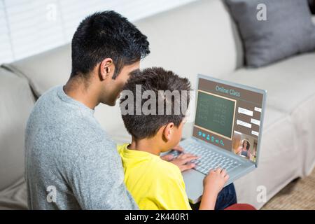 Father and son using laptop on the sofa in living room Stock Photo