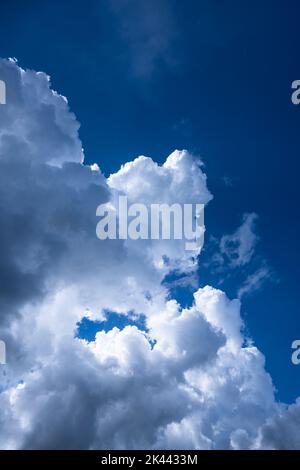 Puffy cumulus clouds against blue sky Stock Photo