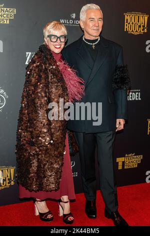 London, UK. 29th Sep, 2022. Filmmaker Baz Luhrmann (R) and his wife Catherine Martin (L) a film costume designer pose on the red carpet at a special Gala night at Moulin Rouge! The Musical in aid of Teenage Cancer Trust. With Baz Luhrmann hosting the night as his film comes to life onstage in London's West End at The Piccadilly Theatre. Credit: SOPA Images Limited/Alamy Live News Stock Photo