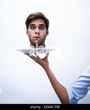 Off with their corporate heads. A businessmans head being served on a plate. Stock Photo