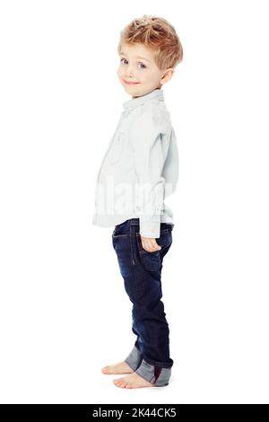 Look how tall Im getting. Side view of a cute little boy standing against a white background - portrait. Stock Photo