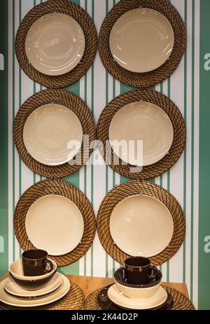 Interior of stylish kitchen with hanging plates on green wall. Hanging kitchen utensil on wall. kitchen interior decor Stock Photo