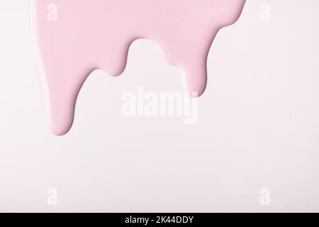 Light pink liquid drops of paint color flow down on isolated white background. Abstract pearl backdrop with rose fluid drip pattern. Acrylic painting Stock Photo