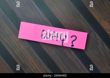 Concept of Why? write on sticky notes isolated on Wooden Table. Stock Photo