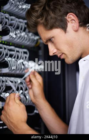 Ready to get you back online. A computer technician connecting cables. Stock Photo