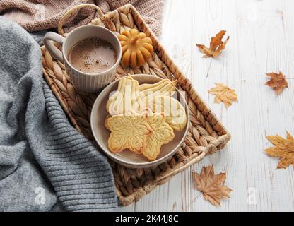 Autumn baking. Cookies in the form of pumpkin and leaves on the table. Cozy autumn concept. Stock Photo