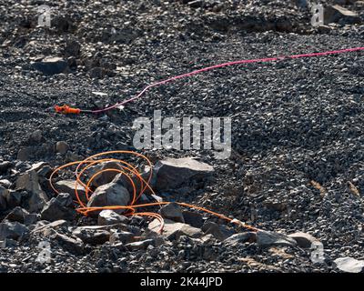 Explosive works in quarry , drilled rocks stuffed with explosives and colorful ignition lines. Holes for explosive filing in basalt mine Stock Photo
