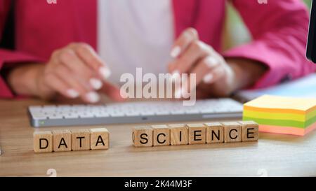 Hands typing on keyboard and data science text on cubes Stock Photo