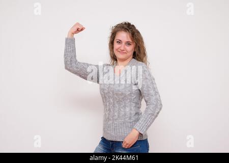 Laughing Young Woman Shows Arm Muscle - Stock Image Stock Photo