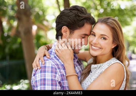 Totally devoted. Portrait of a happy young couple hugging each other in the park. Stock Photo